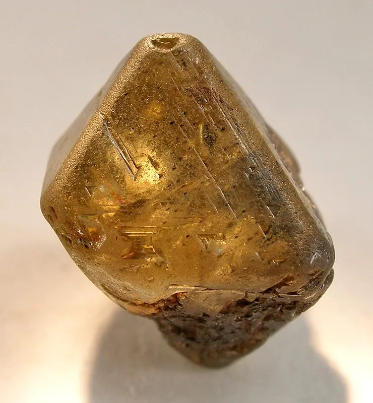 Un diamante en bruto, sin tallar: 42 quilates y esa forma de dos pirámides pegadas por la base. Nadie se la ha dado — le sale así.