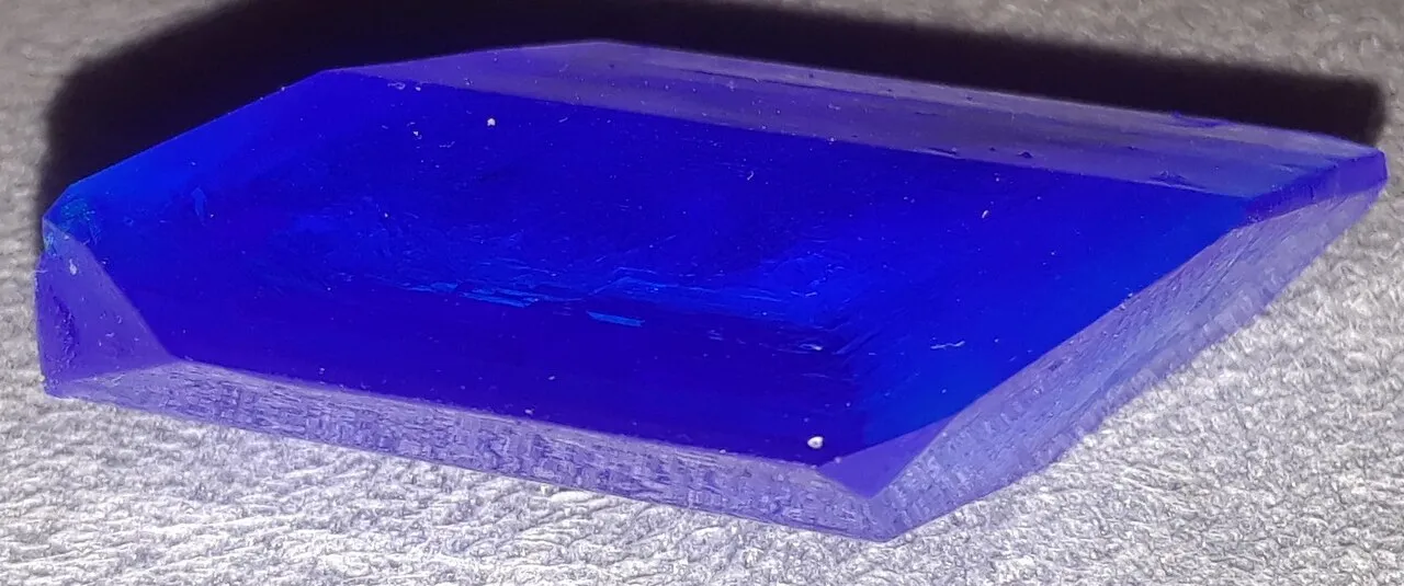 Un monocristal de sulfato de cobre, el azul intenso del laboratorio. Aquí la red es otra y la forma también: una especie de rombo con las caras planas.